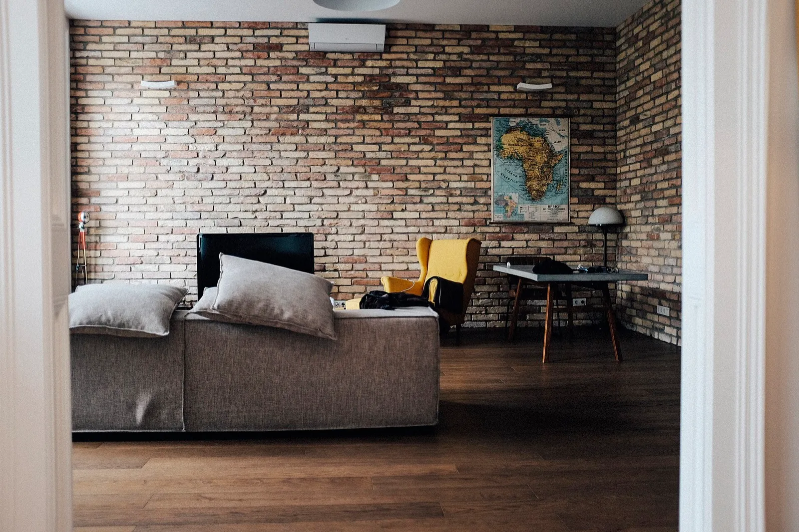 A living room with a sofa facing a flat-screen TV